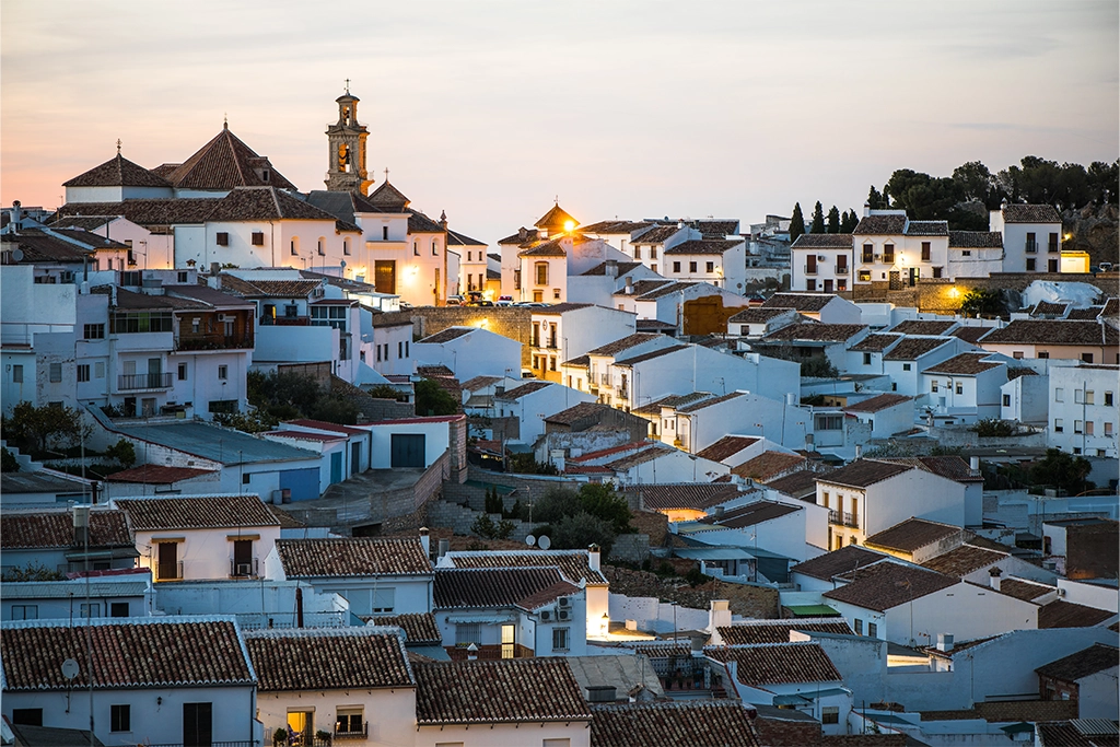 View of Antequera's old town and churches in the distance at dusk.